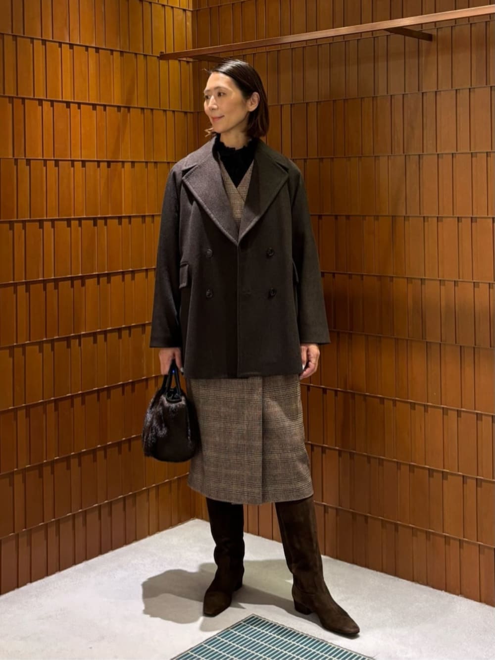 ブラウン系のブーツ、ブラウン系のピーコート、ブラウン系のワンピースを着用したレディースの秋コーディネートの6枚目の写真