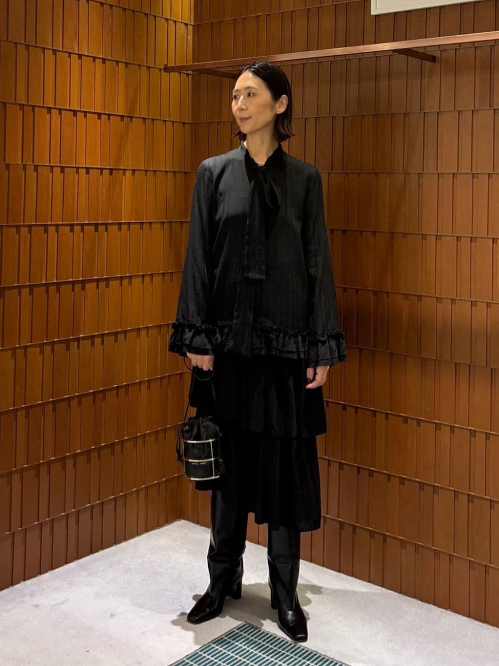 ブラック系のブーツ、ブラック系のダウンジャケット/コート、ブラック系のシャツ/ブラウスを着用したレディースの秋コーディネートの2枚目の写真