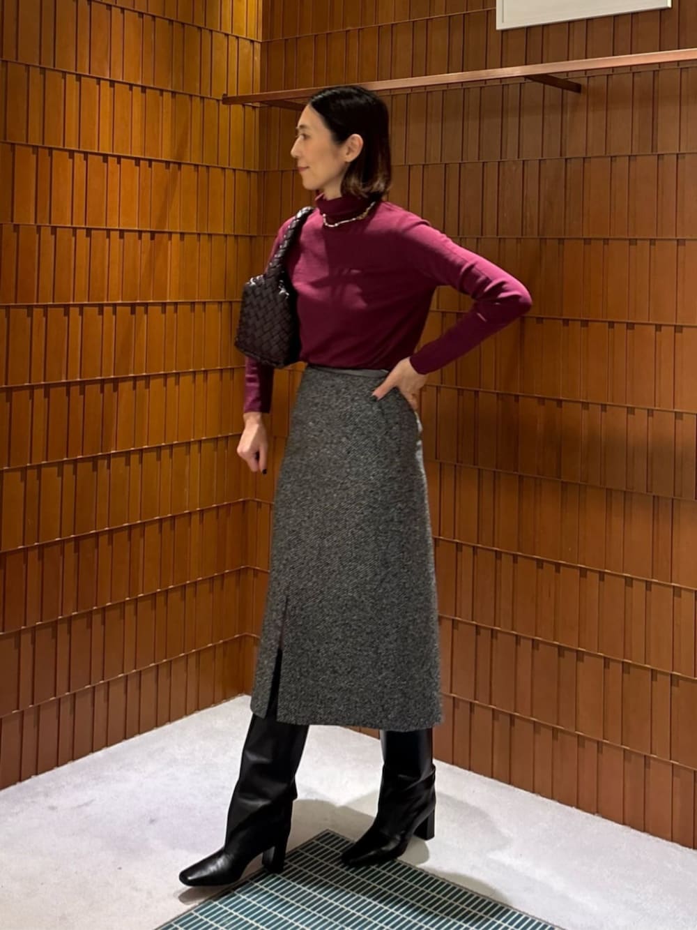 ブラック系のブーツ、ブラック系のステンカラーコート、ブラック系のニット/セーターを着用したレディースの秋コーディネートの2枚目の写真