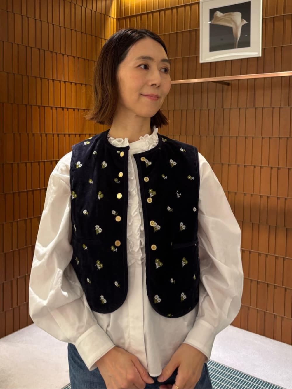 ブルー系のデニムパンツ、ホワイト系のシャツ/ブラウス、ブラック系のチェスターコートを着用したレディースの秋コーディネートの3枚目の写真