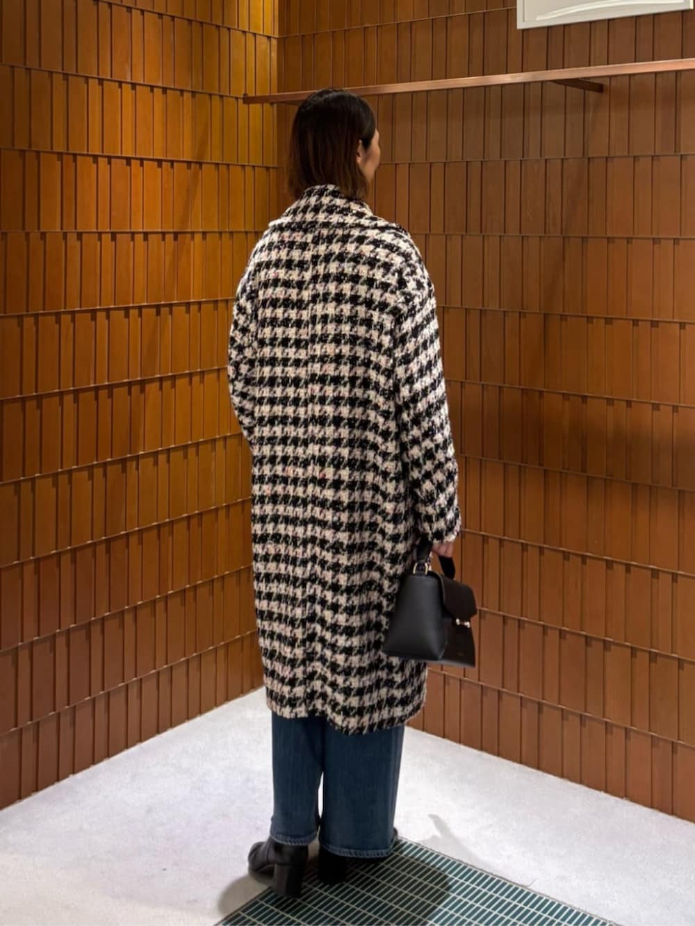 ブルー系のデニムパンツ、ホワイト系のシャツ/ブラウス、ブラック系のチェスターコートを着用したレディースの秋コーディネートの4枚目の写真