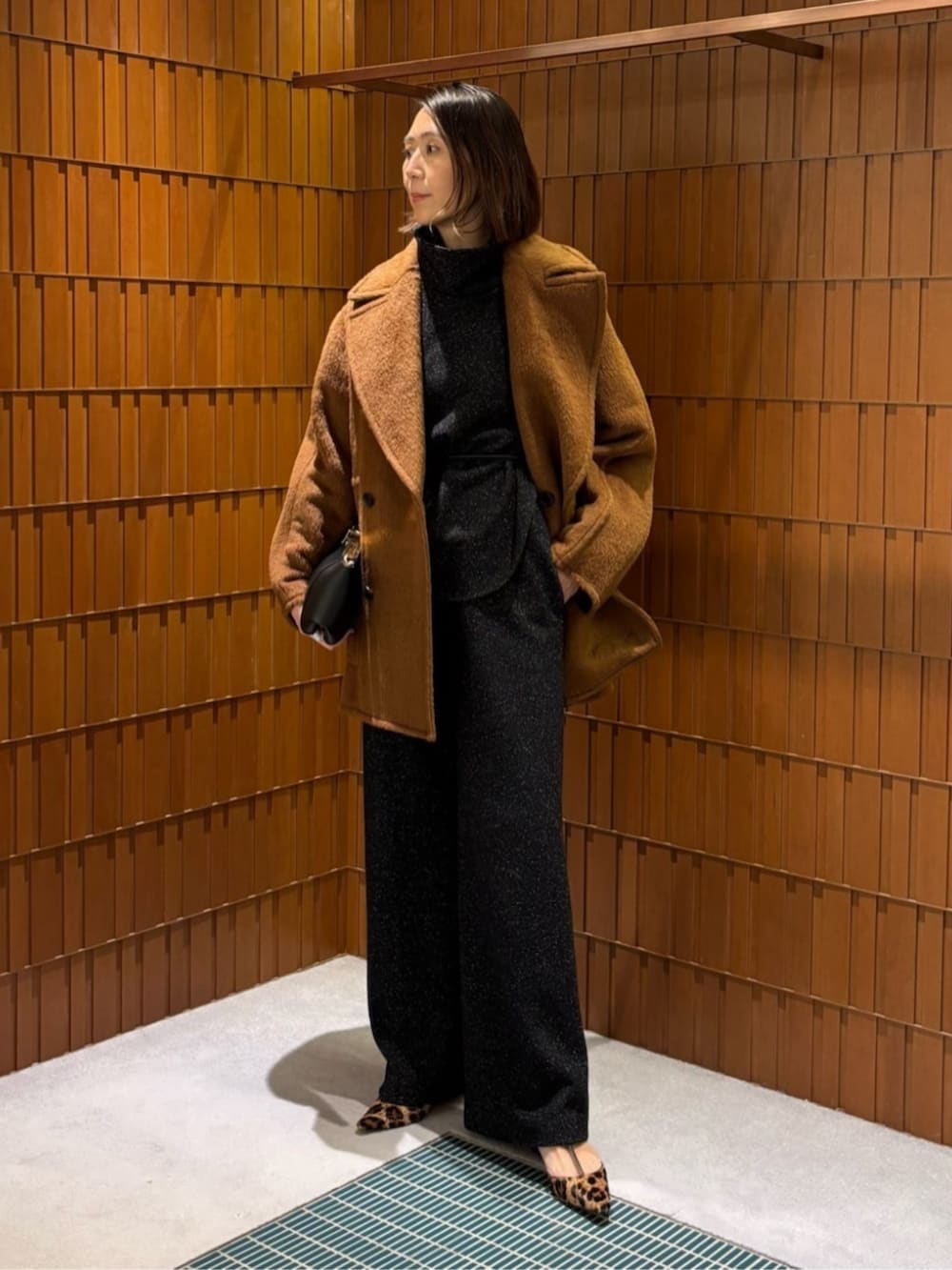 ベージュ系のその他シューズ、ブラウン系のピーコート、ブラック系のTシャツ/カットソーを着用したレディースの秋コーディネートの2枚目の写真