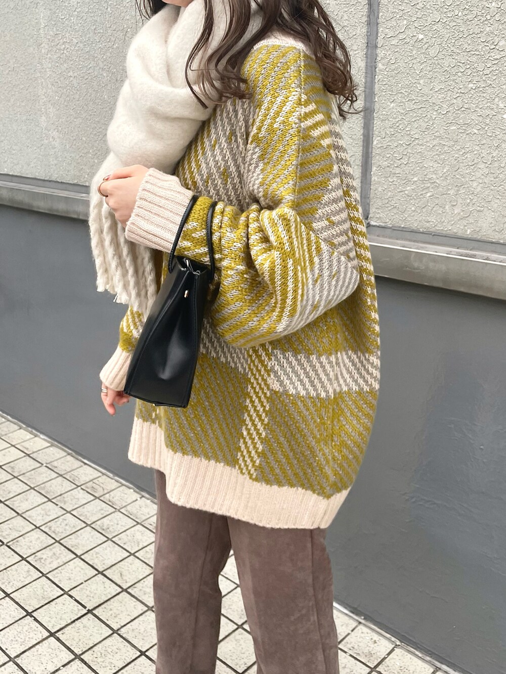 ホワイト系のニット/セーター、ブラック系のショルダーバッグ、ブラウン系のスラックスを着用したレディースの冬コーディネートの4枚目の写真