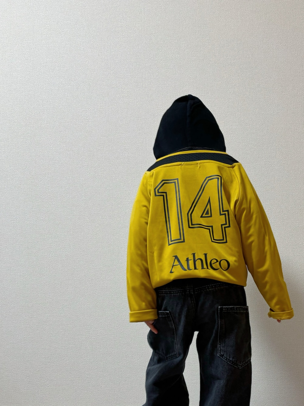 イエロー系のTシャツ/カットソー、ブラック系のパンツ、ブラック系のスニーカーを着用したキッズの秋コーディネートの4枚目の写真