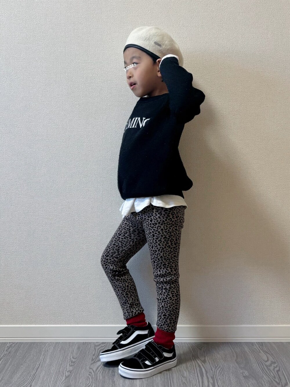 グレー系のニット/セーター、ブラック系のスニーカー、ホワイト系のハンチング/ベレー帽を着用したキッズの秋コーディネートの2枚目の写真