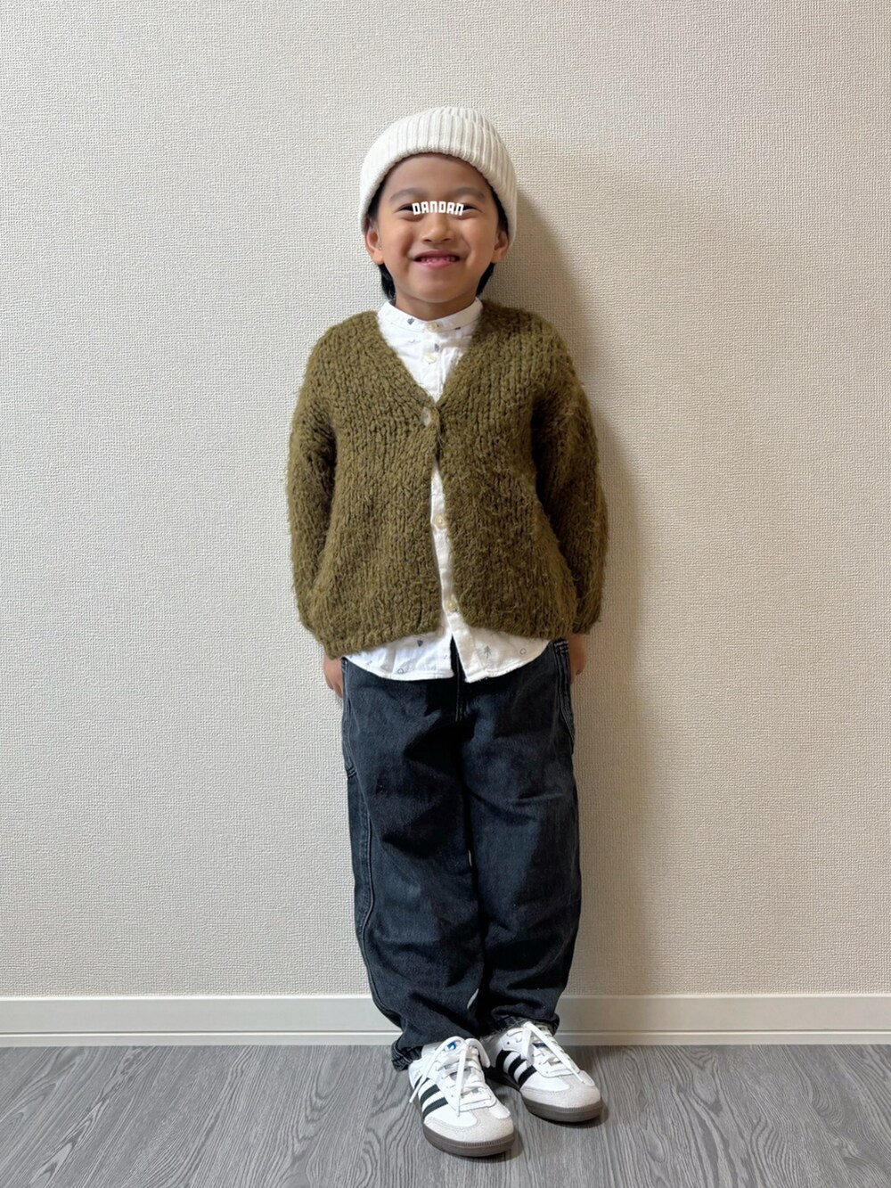 ブラック系のパンツ、ホワイト系のトップス、グリーン系のトップスを着用したキッズの秋コーディネートの2枚目の写真