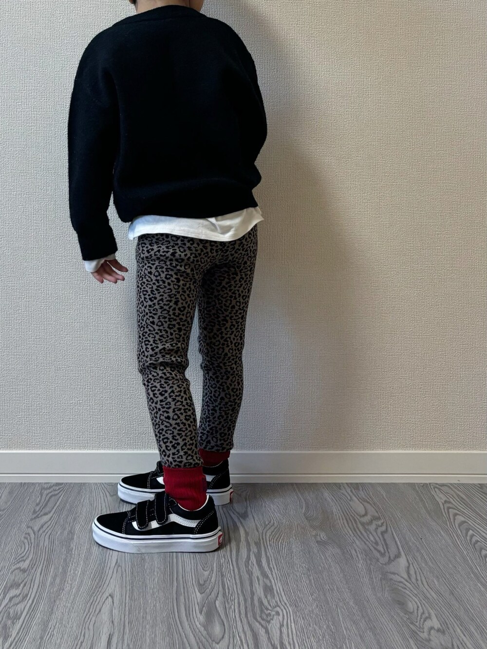 グレー系のニット/セーター、ブラック系のスニーカー、ホワイト系のハンチング/ベレー帽を着用したキッズの秋コーディネートの3枚目の写真