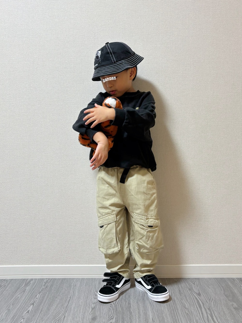 ブラック系のスニーカー、グリーン系のカーゴパンツ、ブラック系のスウェットを着用したキッズの秋コーディネートの2枚目の写真