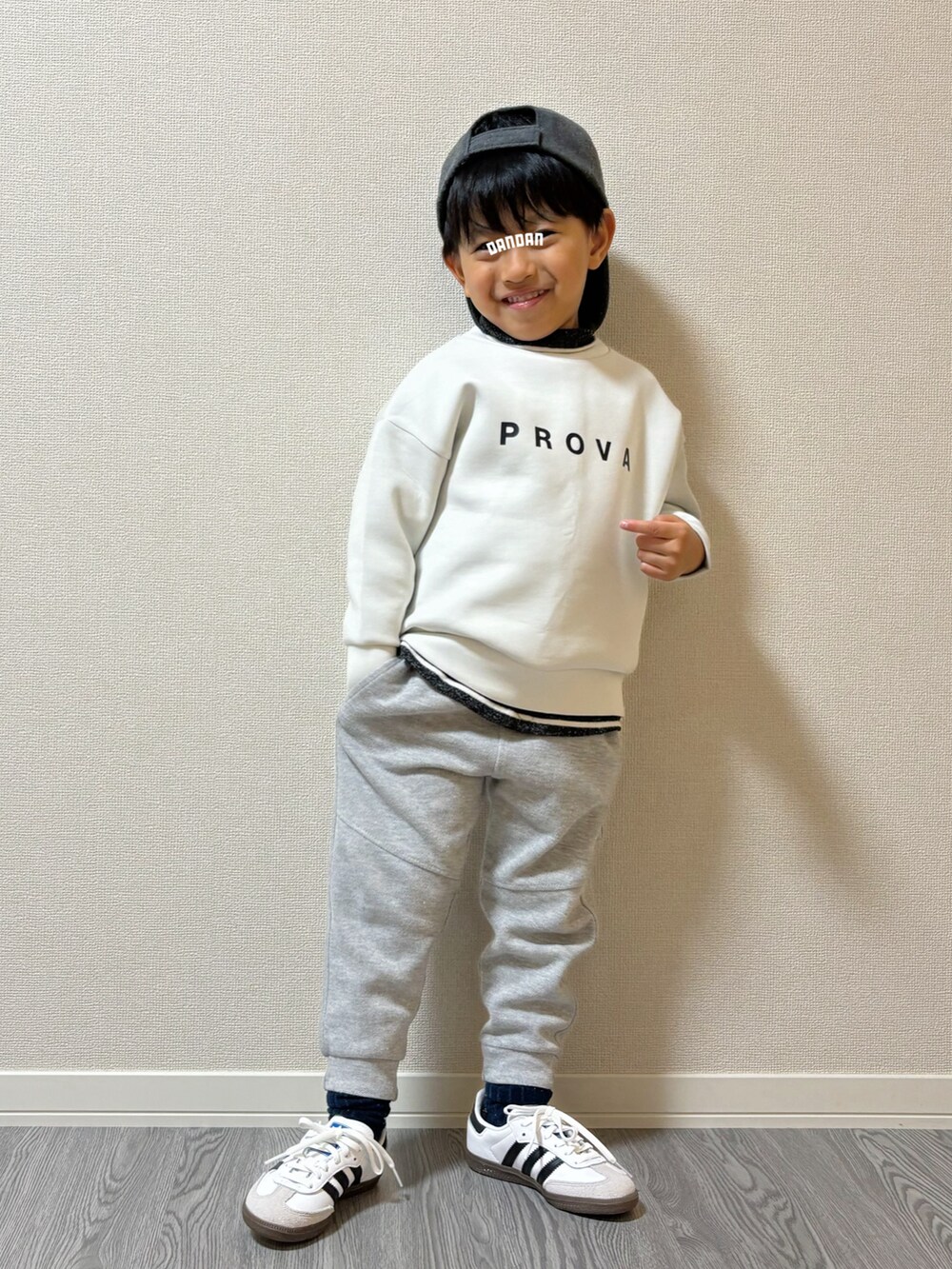 グレー系のパンツ、グレー系のトップス、ホワイト系のスウェットを着用したキッズの秋コーディネートの2枚目の写真