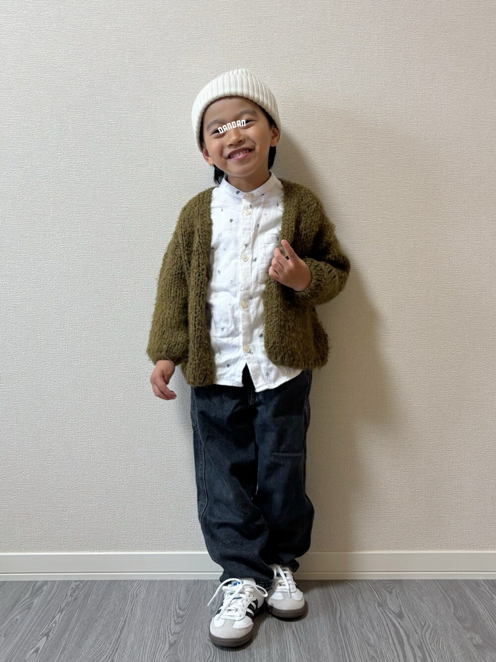 ブラック系のパンツ、ホワイト系のトップス、グリーン系のトップスを着用したキッズの秋コーディネートの3枚目の写真