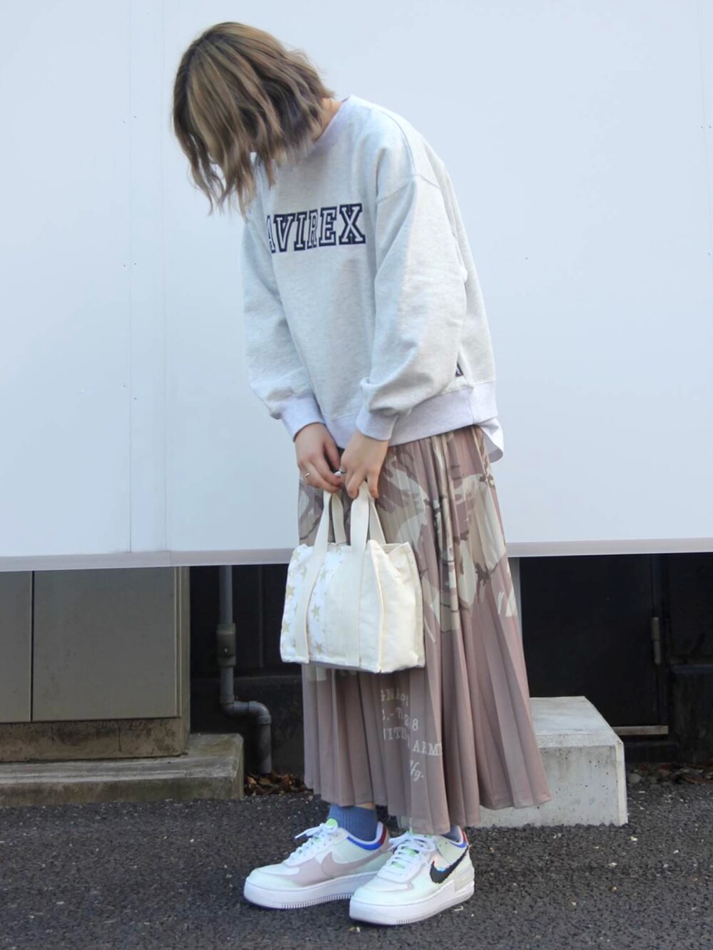 ホワイト系のTシャツ/カットソー、ベージュ系のスカートを着用したレディースの冬コーディネートの2枚目の写真