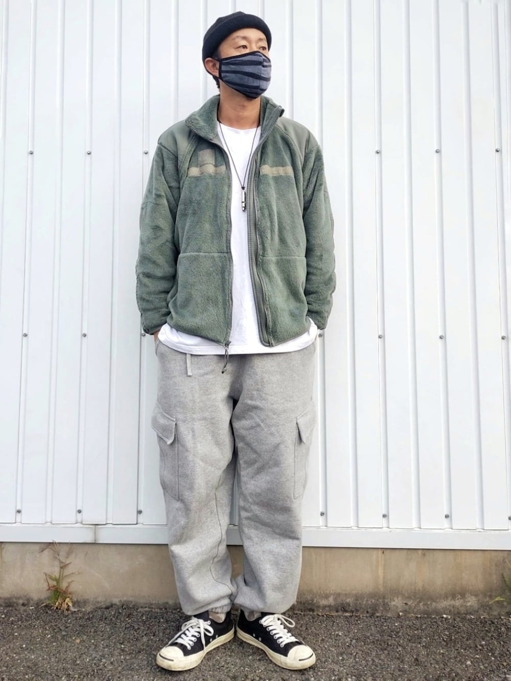 グレー系のその他パンツ、ブラック系のスニーカー、グリーン系のミリタリージャケットを着用したメンズの秋コーディネートの2枚目の写真