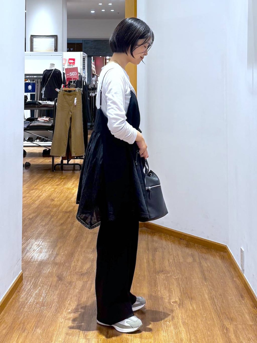 ブラック系のシャツ/ブラウス、グレー系のTシャツ/カットソー、ホワイト系のスニーカーを着用したレディースの夏コーディネートの2枚目の写真