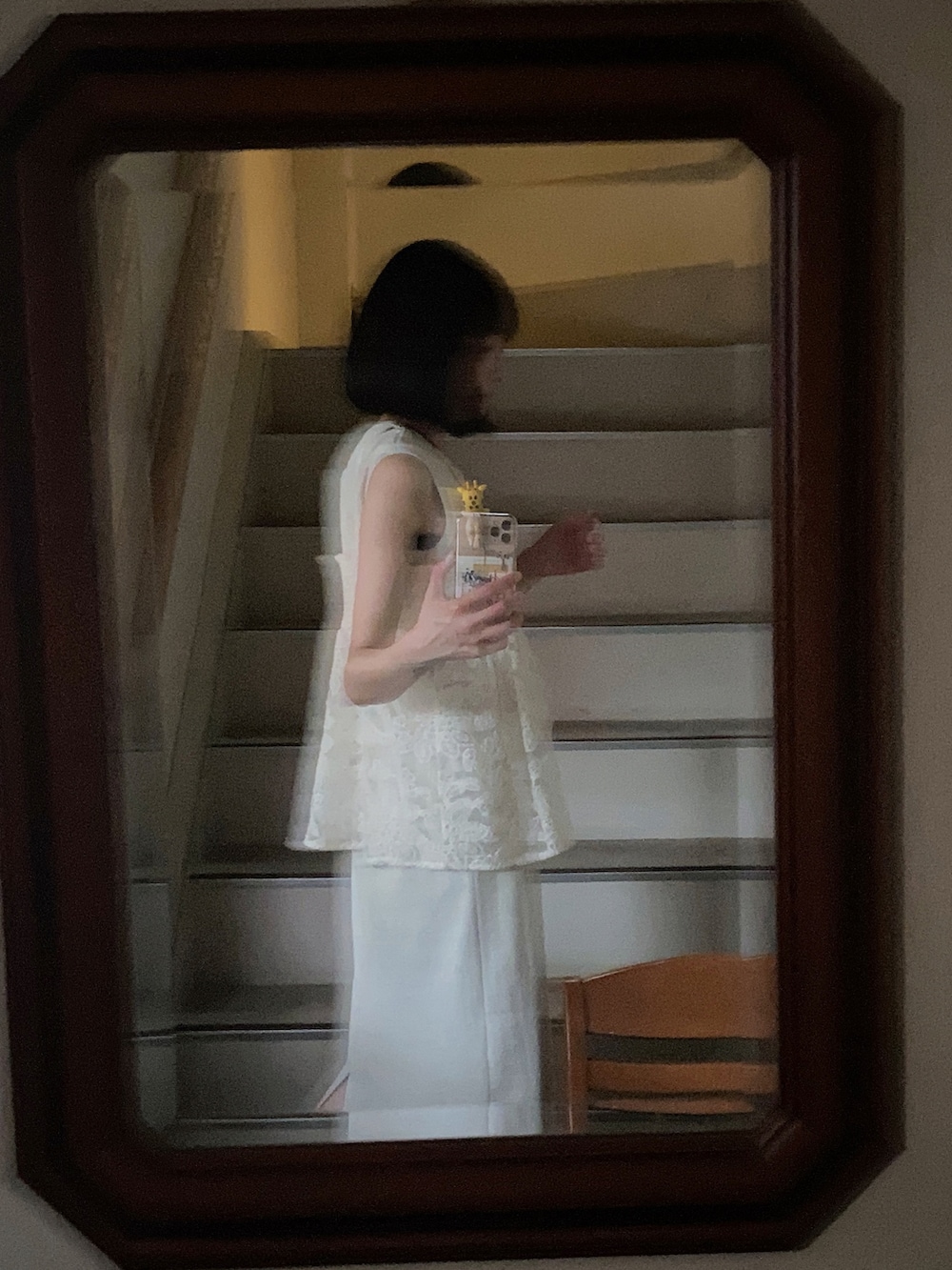 ホワイト系のキャミソール、ベージュ系のワンピース、ブラック系のイヤリングを着用したレディースの夏コーディネートの3枚目の写真