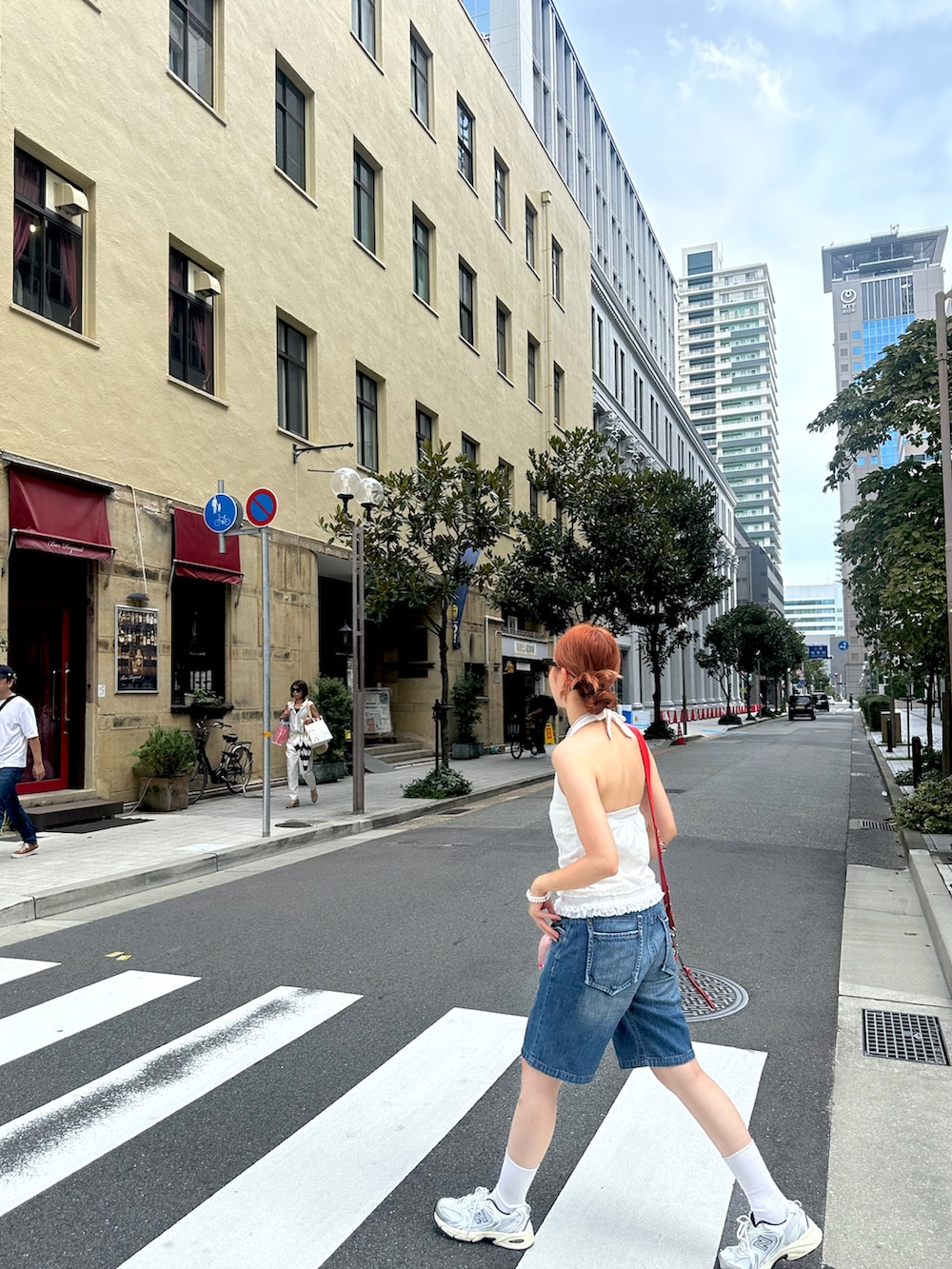 グレー系のスニーカー、レッド系のショルダーバッグを着用したレディースの冬コーディネートの2枚目の写真