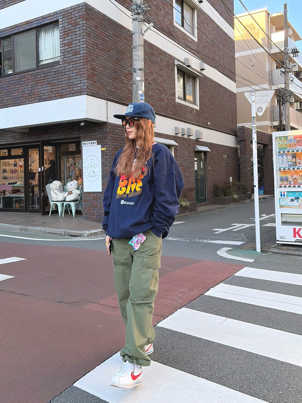 ブルー系のスウェット、グリーン系のカーゴパンツ、ホワイト系のスニーカーを着用したレディースの冬コーディネートの2枚目の写真