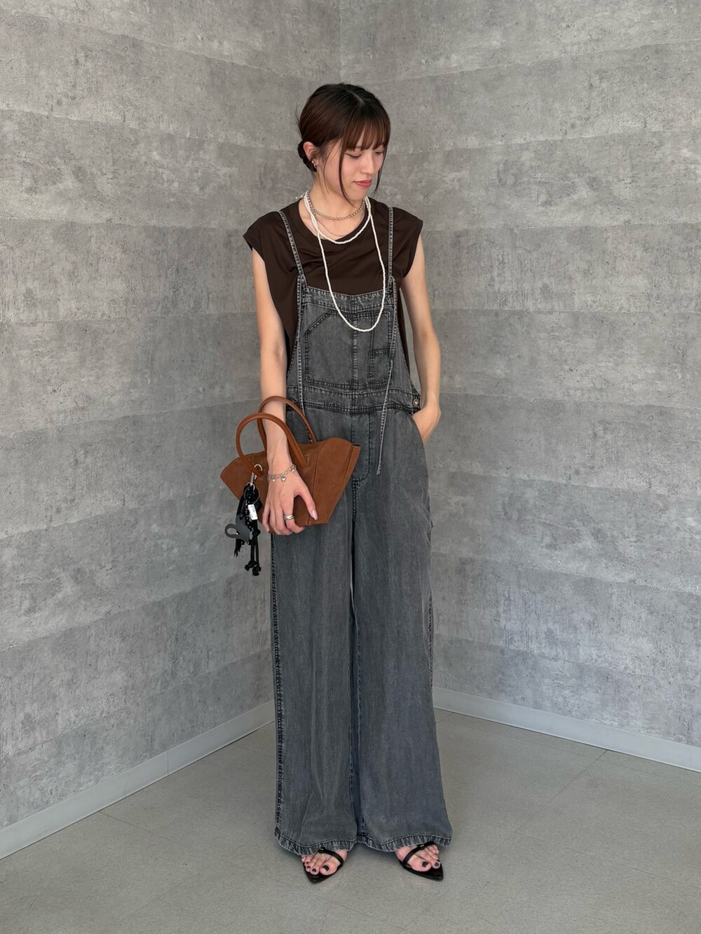 ブラック系のつなぎ/オールインワン、ブラウン系のTシャツ/カットソー、ホワイト系のネックレスを着用したレディースの夏コーディネートの2枚目の写真