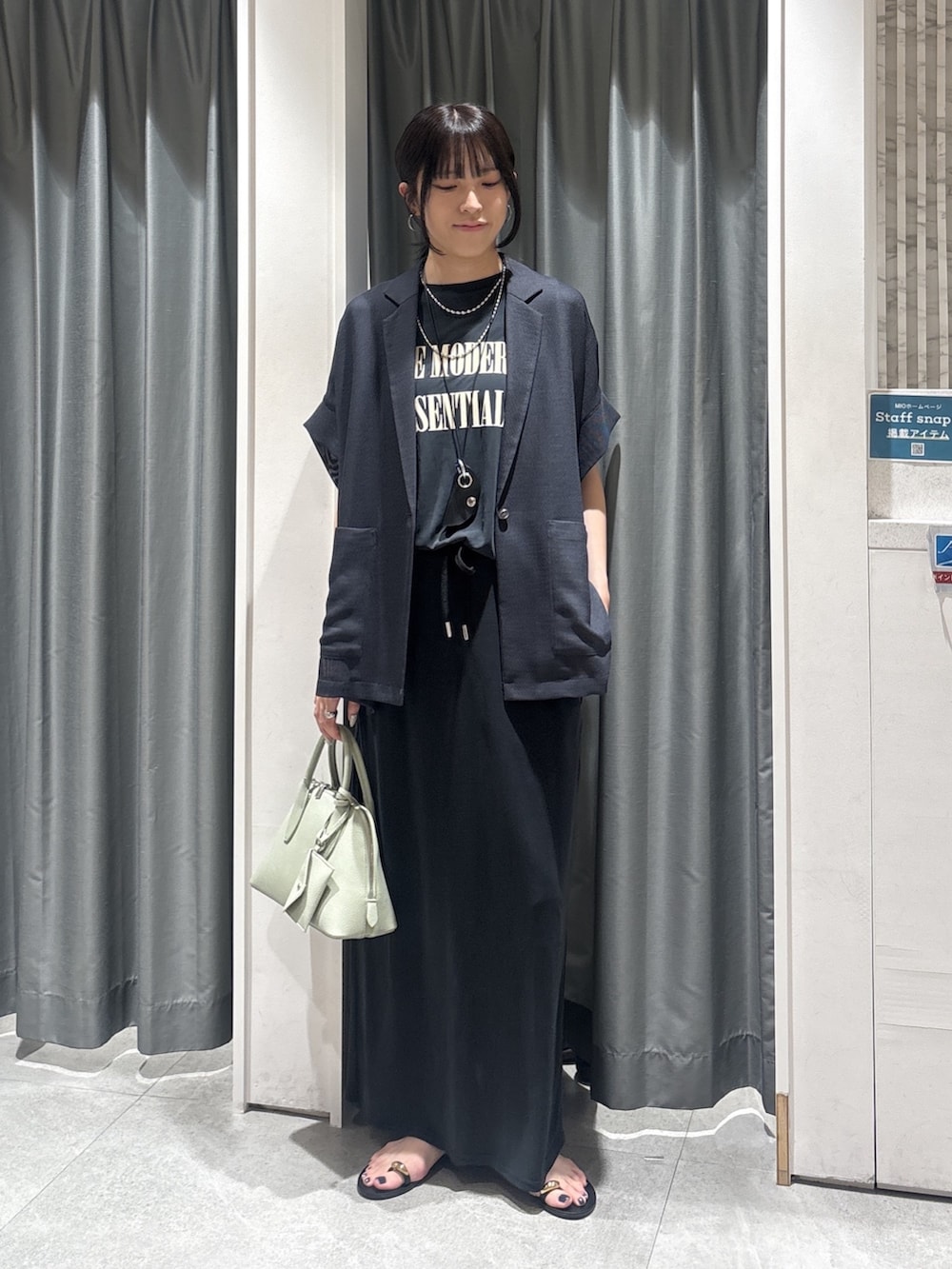 グレー系のテーラードジャケット、ブラック系のTシャツ/カットソー、ブラック系のスカートを着用したレディースの夏コーディネートの4枚目の写真