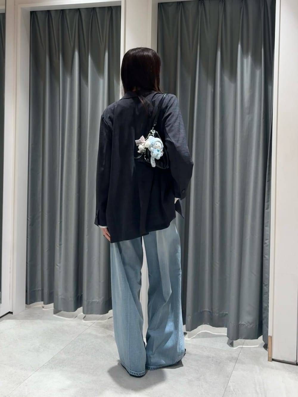 グレー系のテーラードジャケット、ホワイト系のTシャツ/カットソー、ブルー系のデニムパンツを着用したレディースの冬コーディネートの3枚目の写真