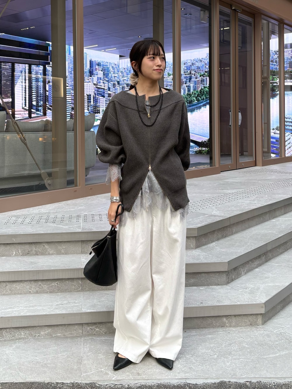 グレー系のニット/セーター、グレー系のTシャツ/カットソーを着用したレディースの冬コーディネートの3枚目の写真