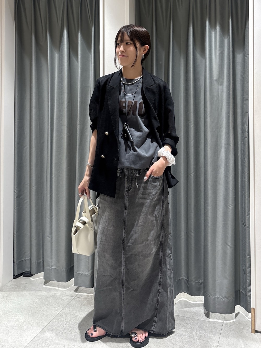 グレー系のTシャツ/カットソー、ブラック系のスカート、ブラック系のネックレスを着用したレディースの夏コーディネートの2枚目の写真