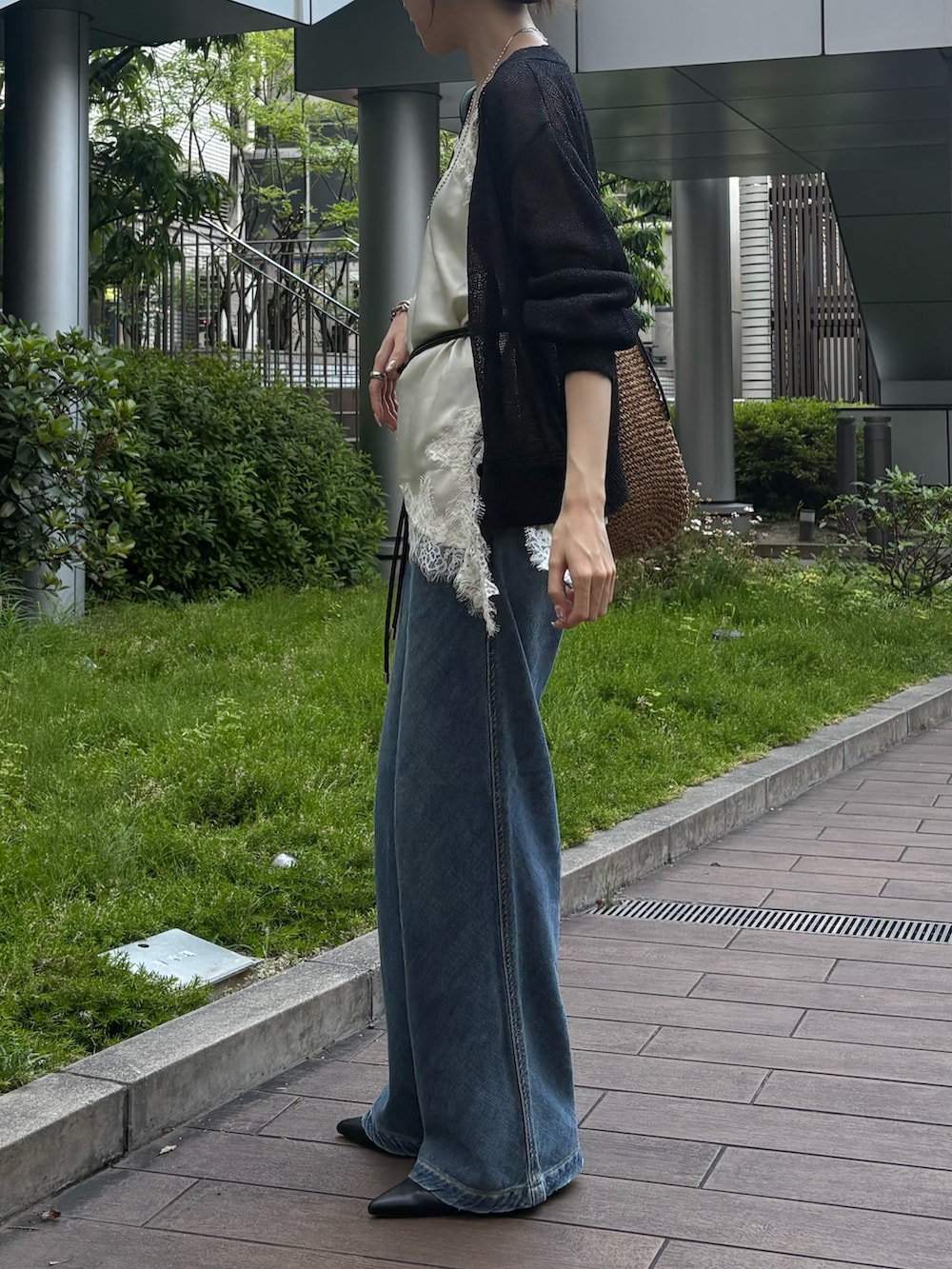 ブラック系のカーディガン/ボレロ、ホワイト系のシャツ/ブラウス、ブルー系のデニムパンツを着用したレディースの春コーディネートの3枚目の写真