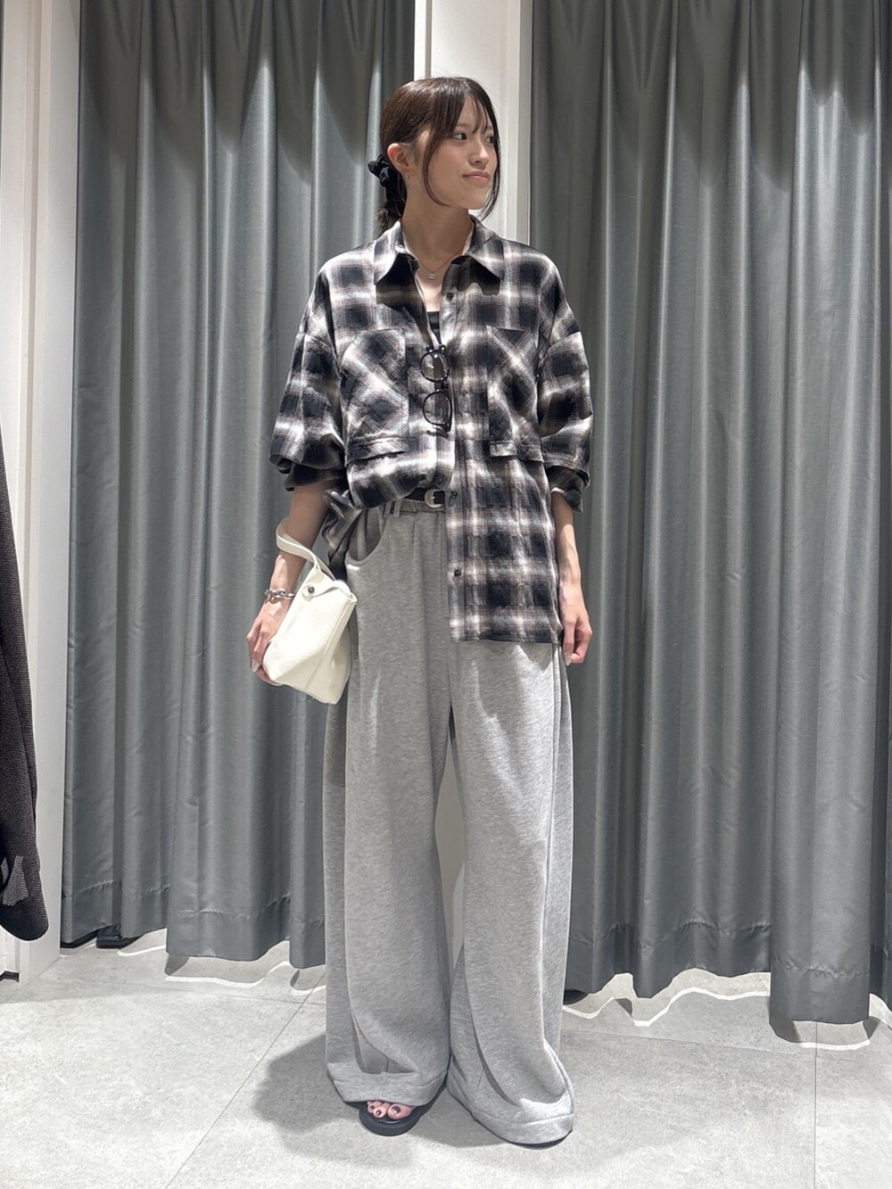 ブラック系のシャツ/ブラウス、ホワイト系のショルダーバッグ、グレー系のスウェットパンツを着用したレディースの夏コーディネートの2枚目の写真