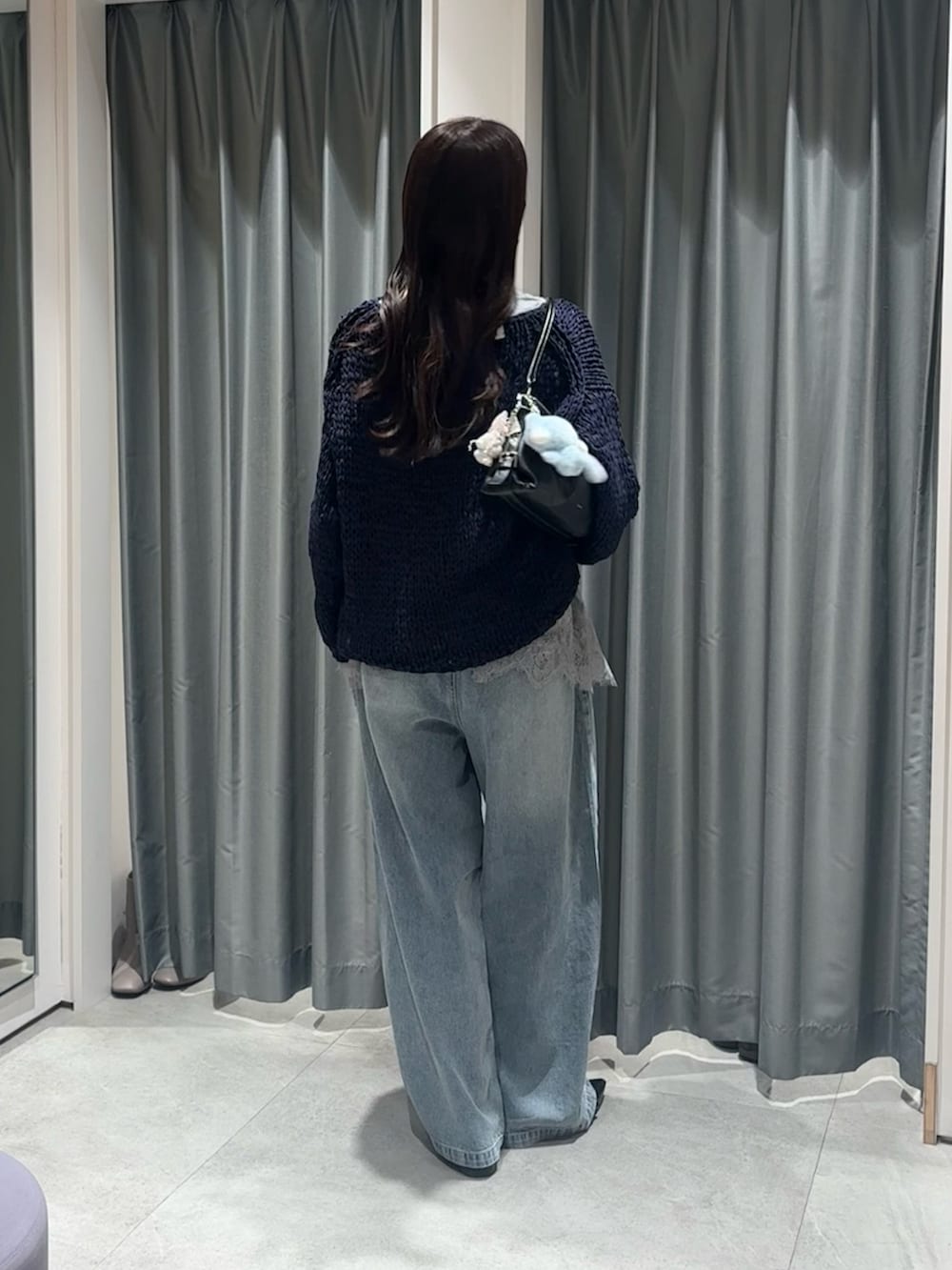 ブルー系のニット/セーター、グレー系のTシャツ/カットソー、ブルー系のデニムパンツを着用したレディースの冬コーディネートの4枚目の写真