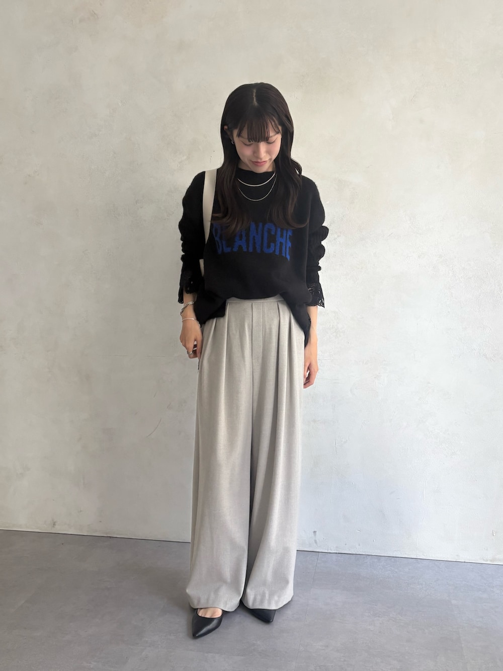 ブラック系のニット/セーター、ブラック系のシャツ/ブラウス、グレー系のその他パンツを着用したレディースの秋コーディネートの3枚目の写真