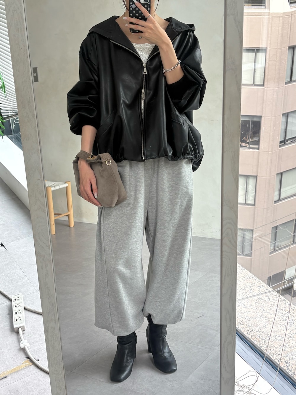 ブラック系のブルゾン、ホワイト系のシャツ/ブラウス、グレー系のスウェットパンツを着用したレディースの秋コーディネートの3枚目の写真