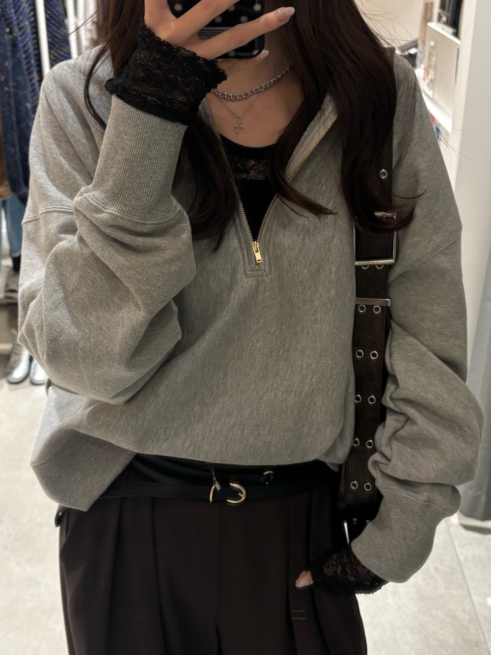 グレー系のスウェット、ブラック系のTシャツ/カットソー、ブラウン系のスラックスを着用したレディースの冬コーディネートの4枚目の写真