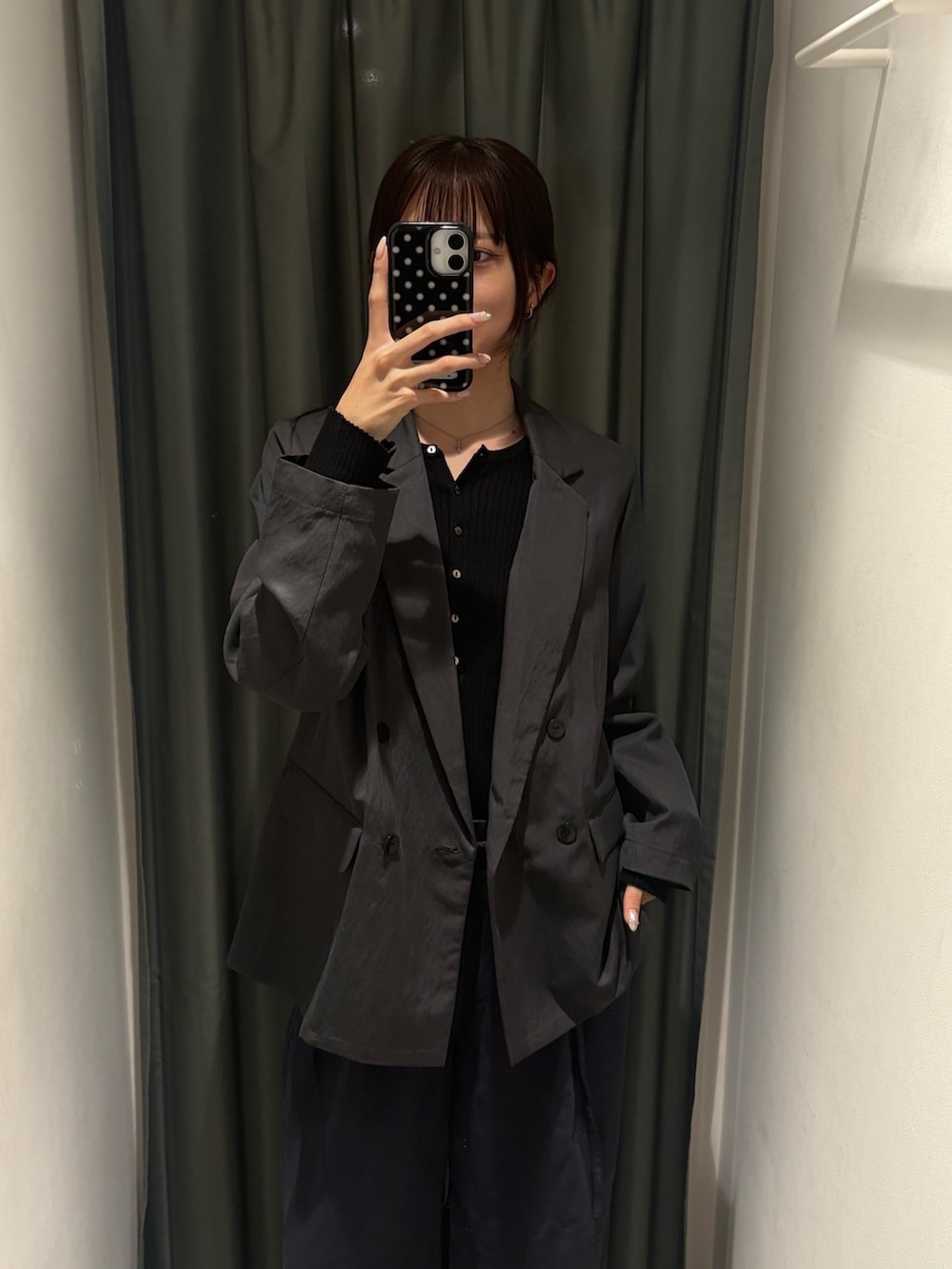 グレー系のテーラードジャケット、ブラック系のニット/セーターを着用したレディースの春コーディネートの2枚目の写真