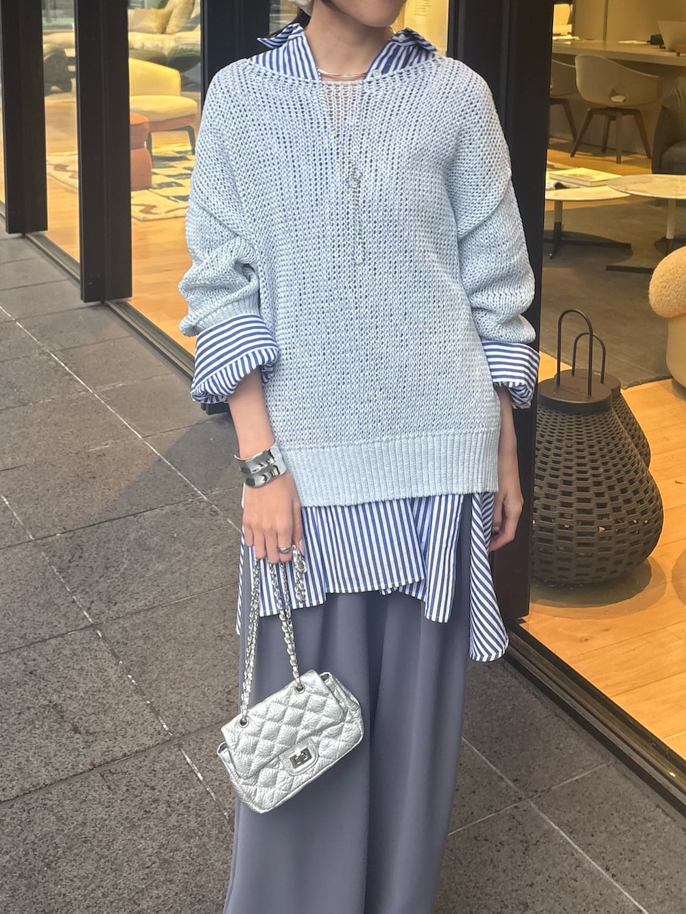 ブルー系のニット/セーター、ブルー系のシャツ/ブラウス、グレー系のスラックスを着用したレディースの冬コーディネートの3枚目の写真