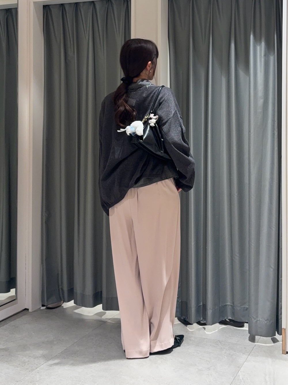 ブラック系のシャツ/ブラウス、グレー系のニット/セーター、ピンク系のスラックスを着用したレディースの春コーディネートの4枚目の写真