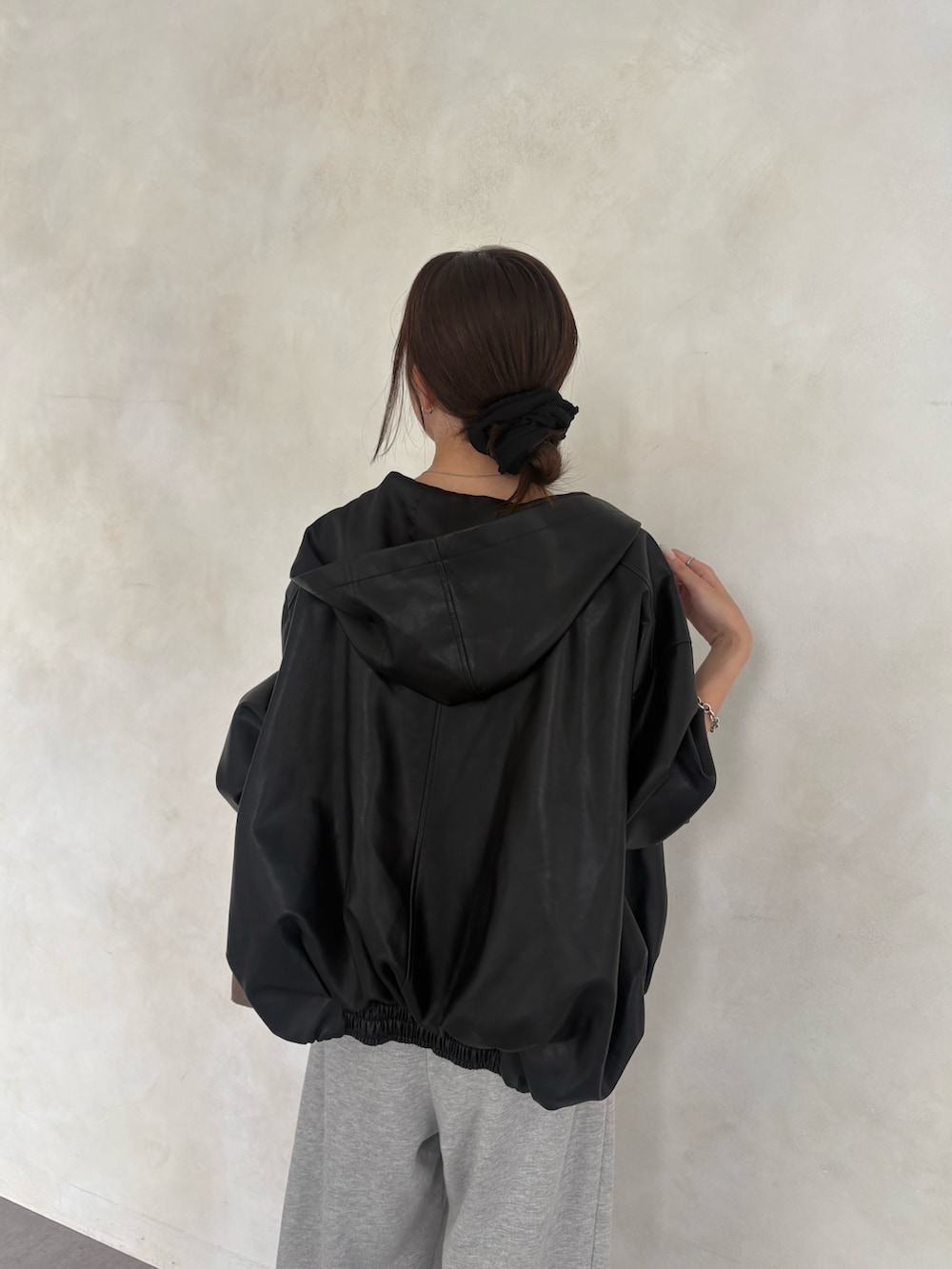 ブラック系のブルゾン、ホワイト系のシャツ/ブラウス、グレー系のスウェットパンツを着用したレディースの秋コーディネートの2枚目の写真