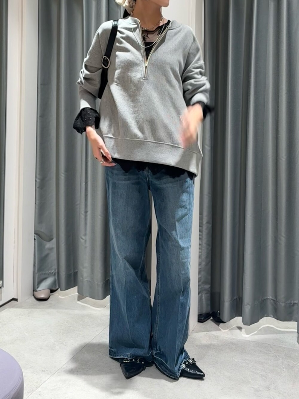 グレー系のスウェット、ブラック系のシャツ/ブラウス、ブルー系のデニムパンツを着用したレディースの冬コーディネートの3枚目の写真