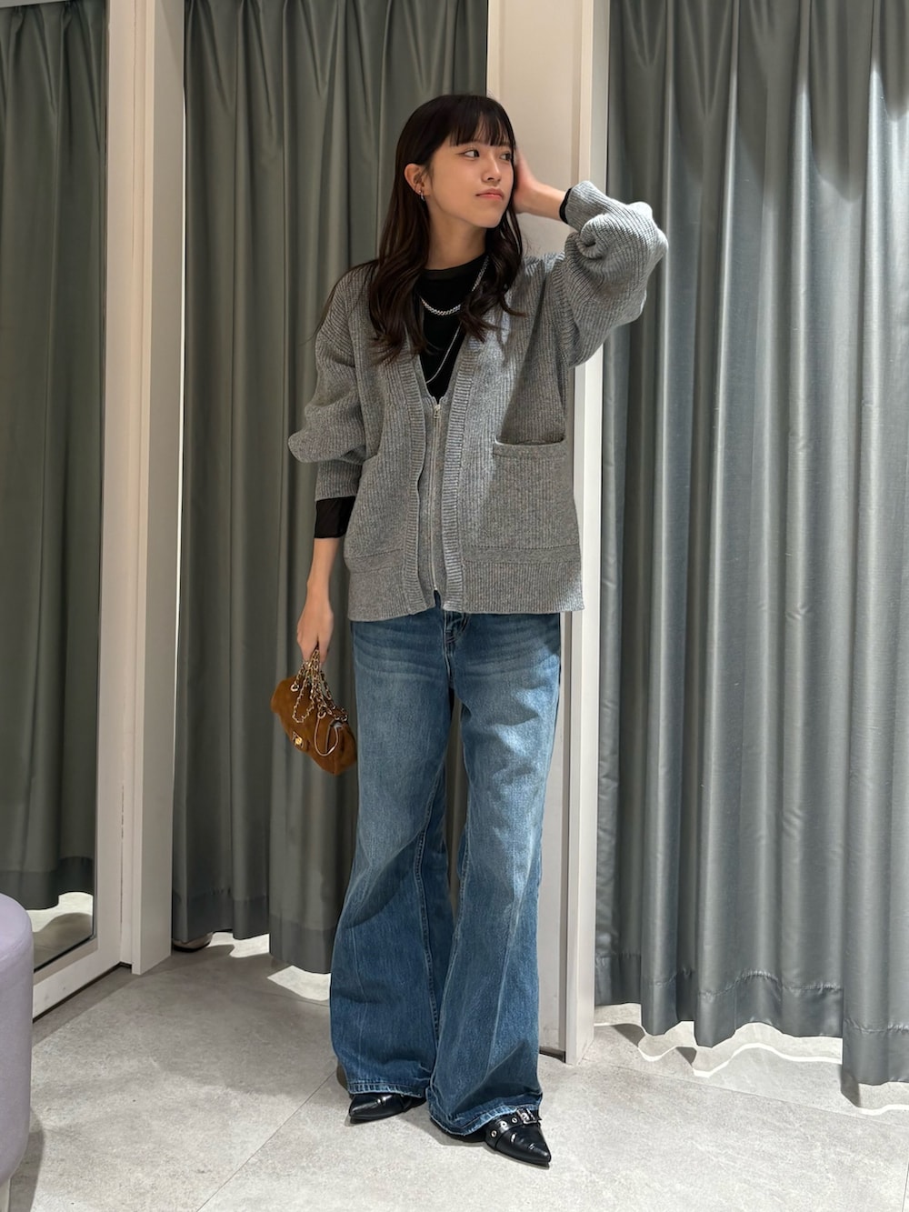 ブラック系のTシャツ/カットソー、グレー系のカーディガン/ボレロ、ブルー系のデニムパンツを着用したレディースの冬コーディネートの2枚目の写真