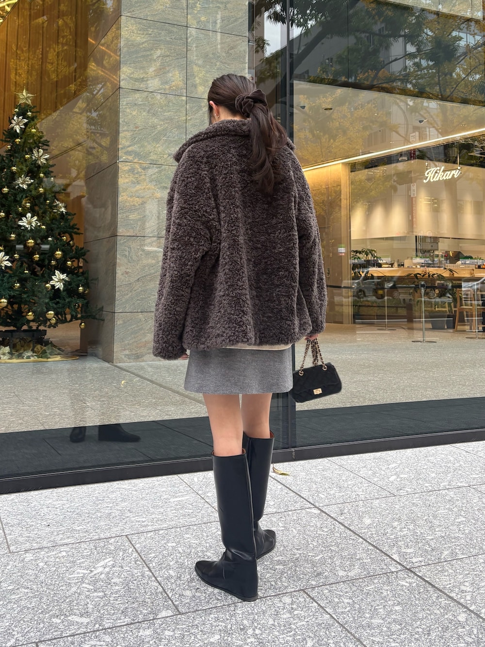 グレー系のその他アウター、グレー系のスカート、ブラック系のブーツを着用したレディースの冬コーディネートの3枚目の写真
