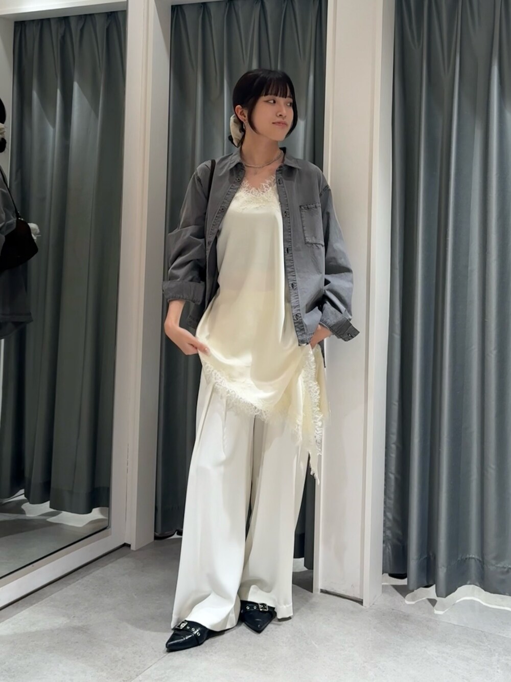 ブラック系のシャツ/ブラウス、ホワイト系のキャミソール、ホワイト系のスラックスを着用したレディースの冬コーディネートの2枚目の写真