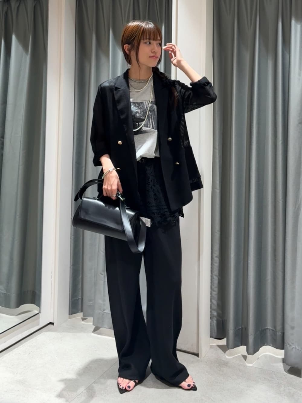 ブラック系のテーラードジャケット、グレー系のTシャツ/カットソー、ブラック系のショルダーバッグを着用したレディースの夏コーディネートの2枚目の写真