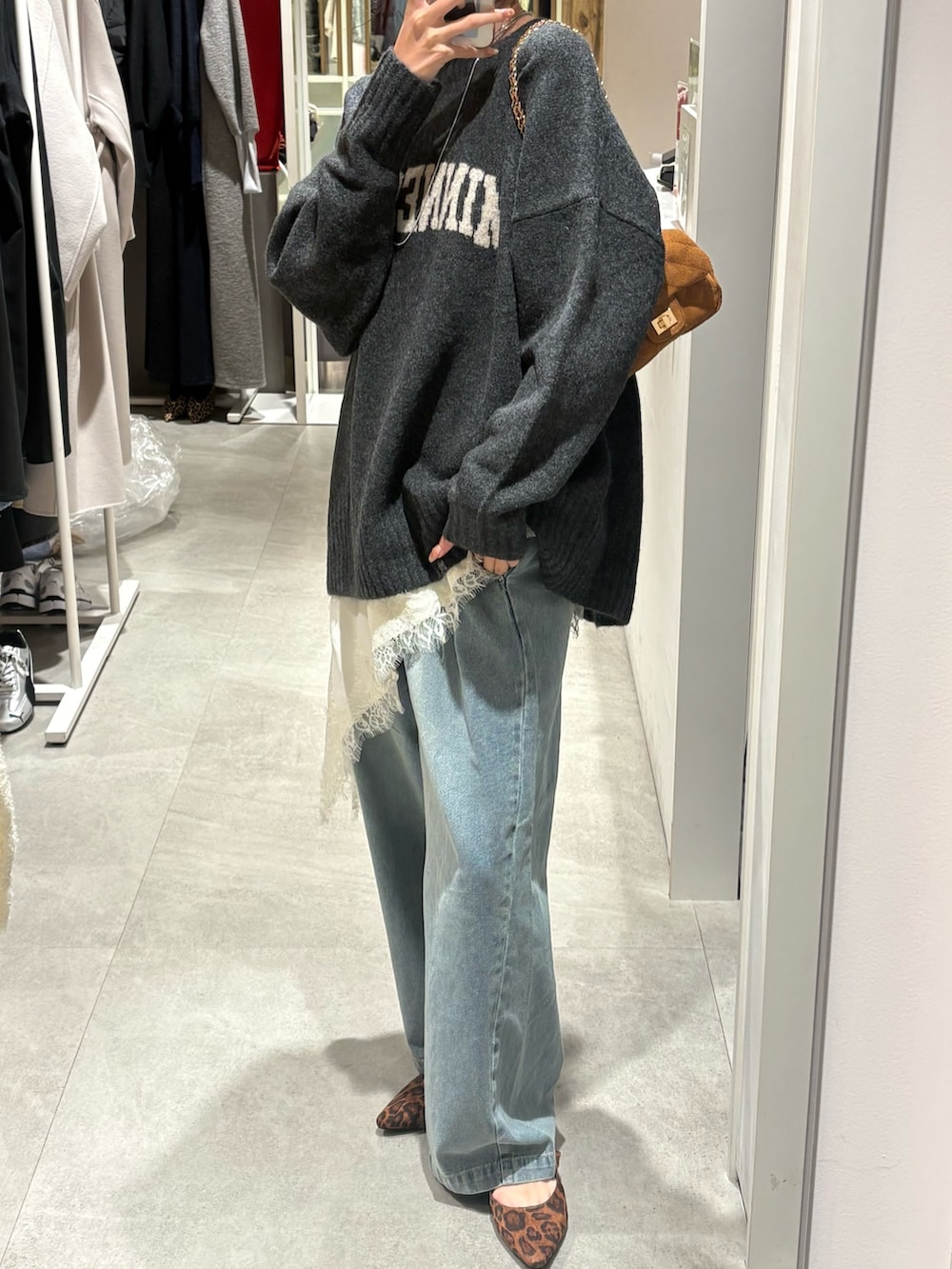 グレー系のニット/セーター、ホワイト系のキャミソール、ブルー系のデニムパンツを着用したレディースの冬コーディネートの4枚目の写真