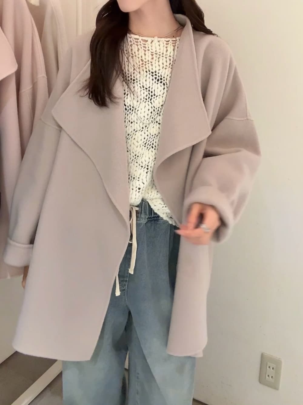 ブラック系のその他アウター、ホワイト系のニット/セーター、ブルー系のデニムパンツを着用したレディースの冬コーディネートの3枚目の写真