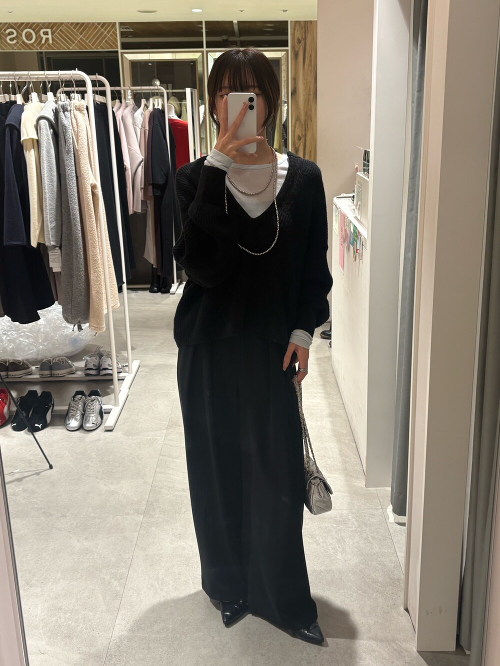 ブラック系のニット/セーター、ブルー系のTシャツ/カットソー、ブラック系のスラックスを着用したレディースの冬コーディネートの2枚目の写真