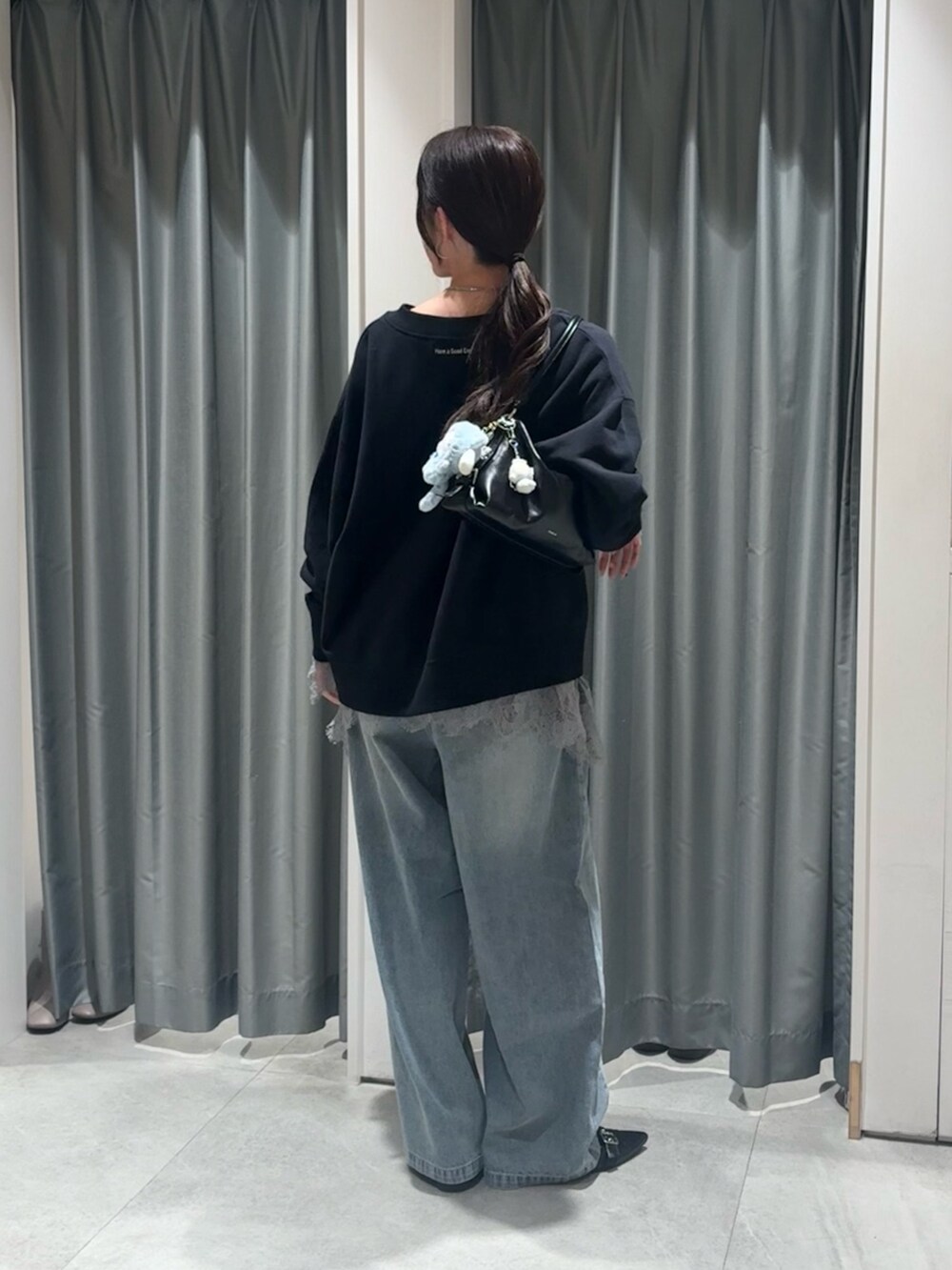 ブラック系のスウェット、グレー系のTシャツ/カットソー、ブルー系のデニムパンツを着用したレディースの冬コーディネートの2枚目の写真