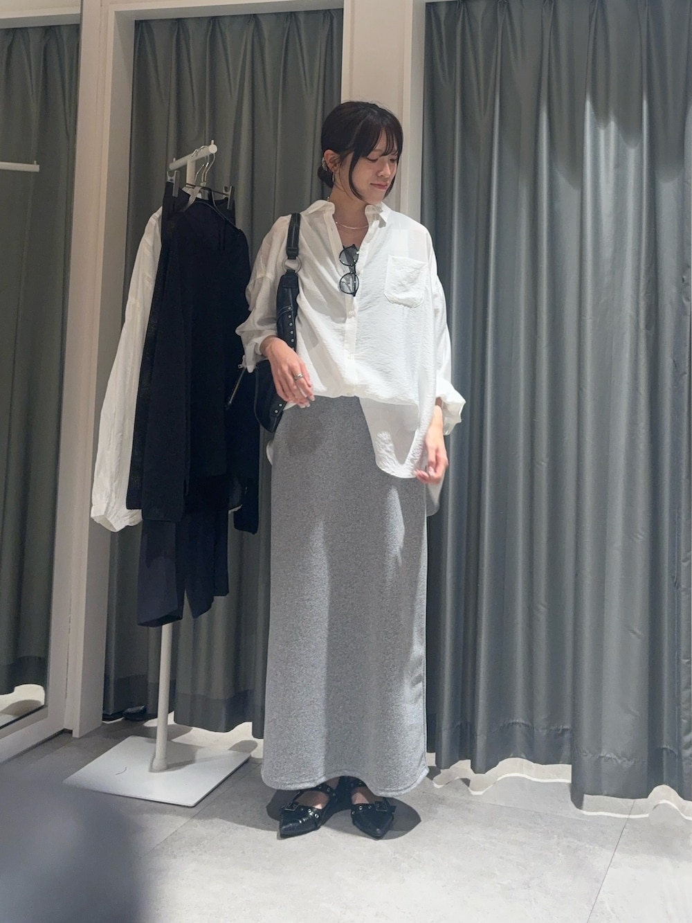 ブラック系のワンピース、ホワイト系のシャツ/ブラウス、グレー系のサングラスを着用したレディースの春コーディネートの2枚目の写真