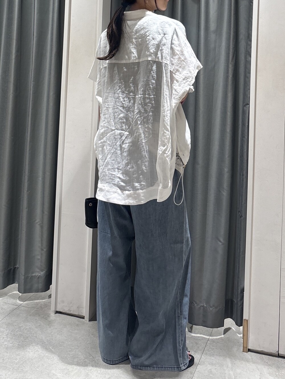 ホワイト系のシャツ/ブラウス、ブラック系のTシャツ/カットソー、ブルー系のデニムパンツを着用したレディースの夏コーディネートの3枚目の写真