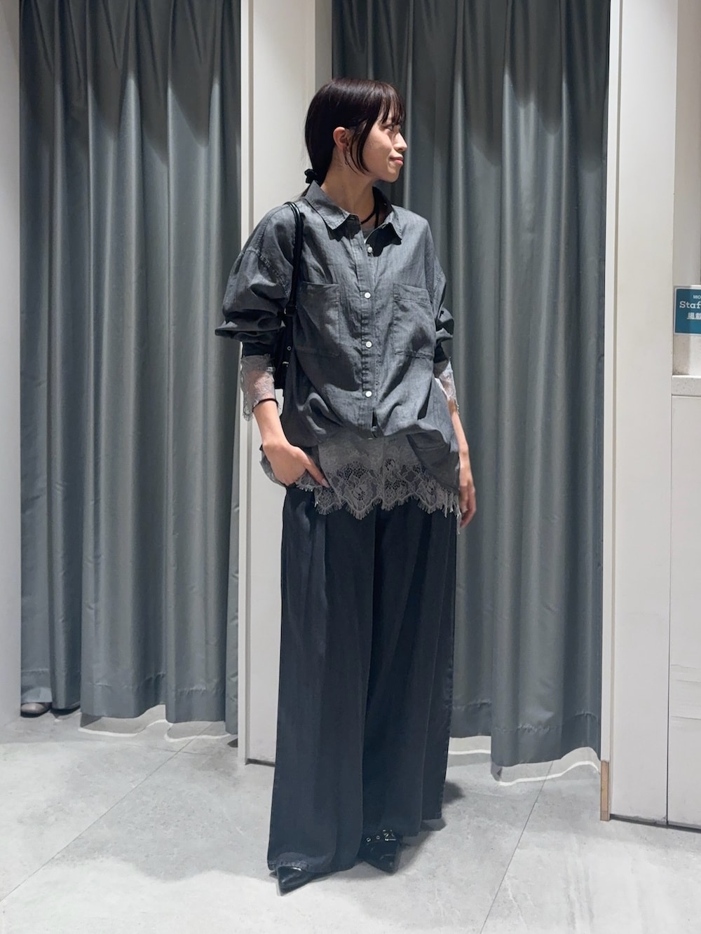 ブラック系のシャツ/ブラウス、グレー系のTシャツ/カットソー、ブラック系のデニムパンツを着用したレディースの春コーディネートの2枚目の写真