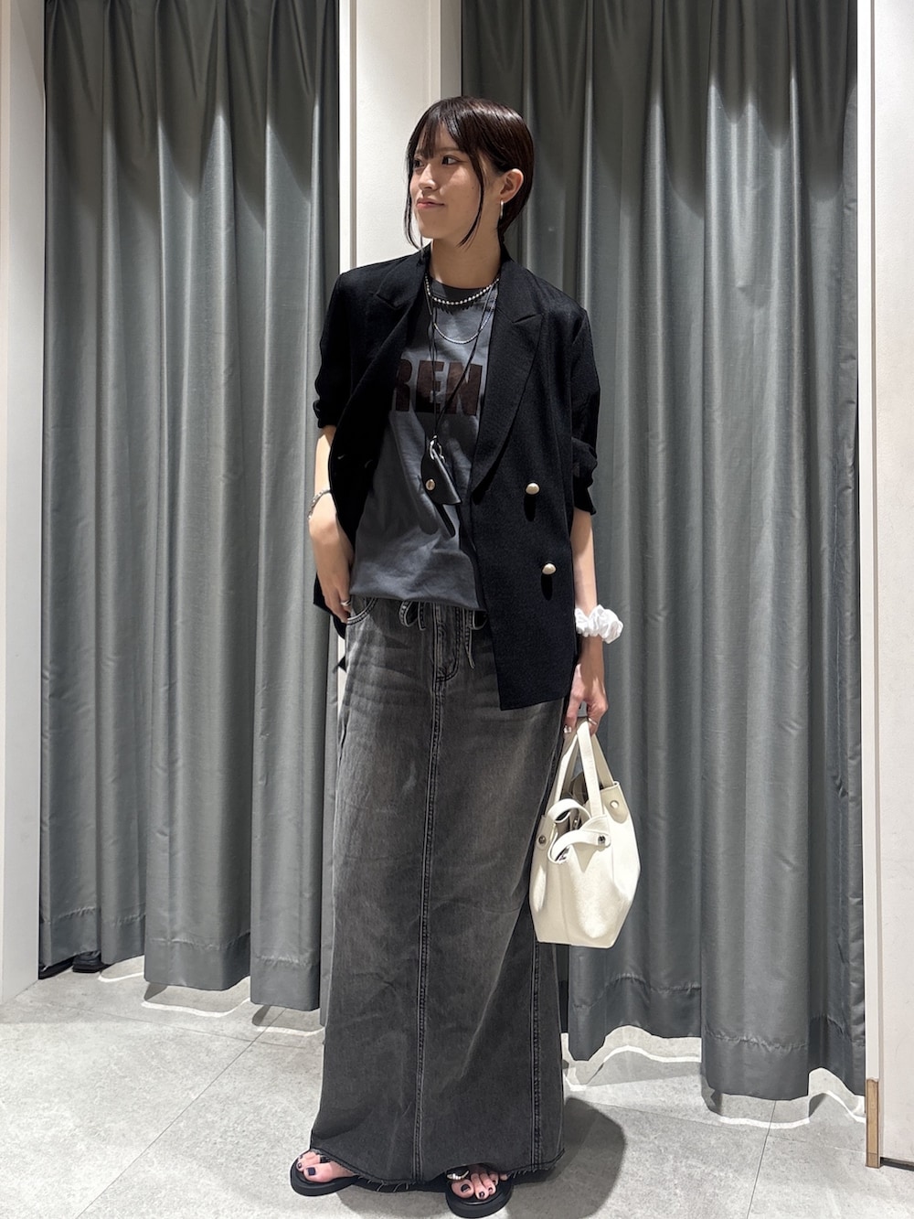グレー系のTシャツ/カットソー、ブラック系のスカート、ブラック系のネックレスを着用したレディースの夏コーディネートの3枚目の写真