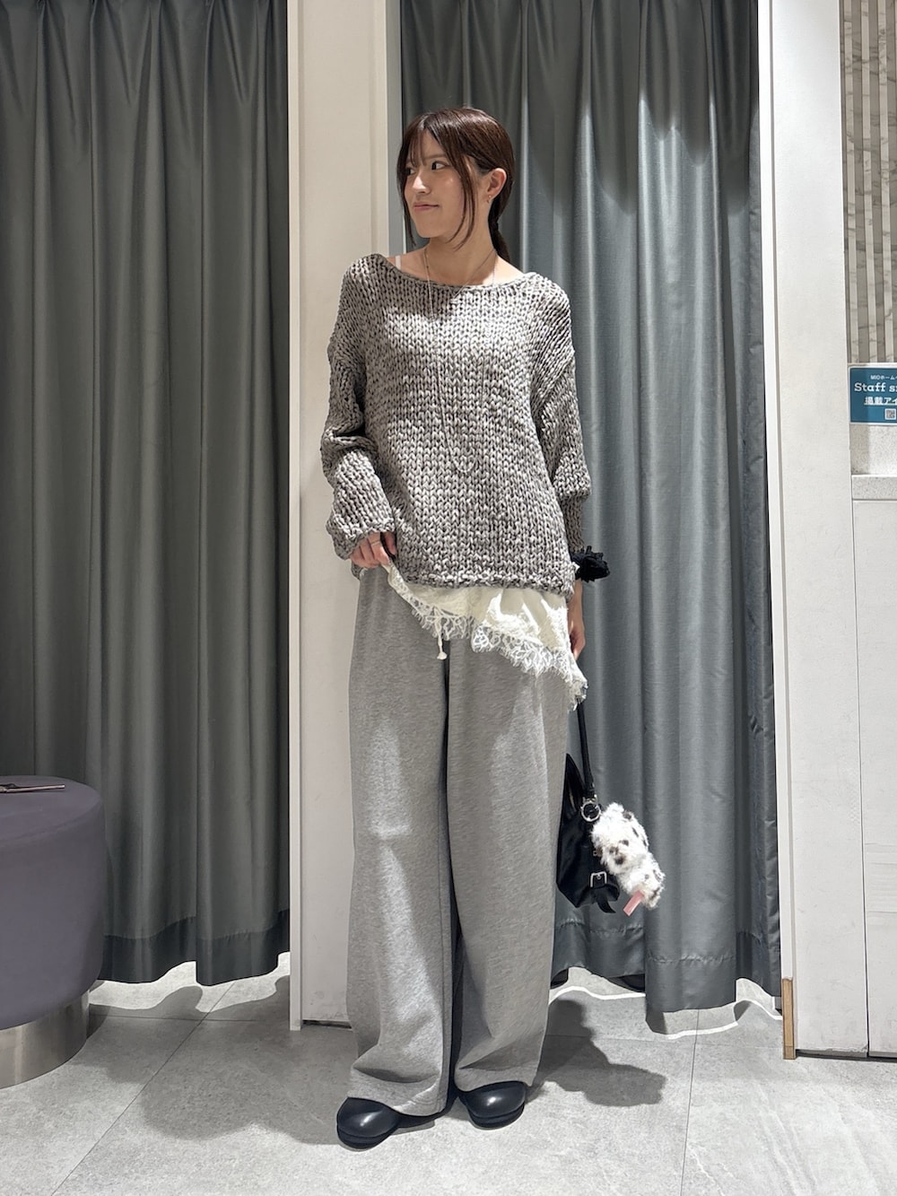 グレー系のニット/セーター、ホワイト系のシャツ/ブラウス、グレー系のその他パンツを着用したレディースの秋コーディネートの2枚目の写真