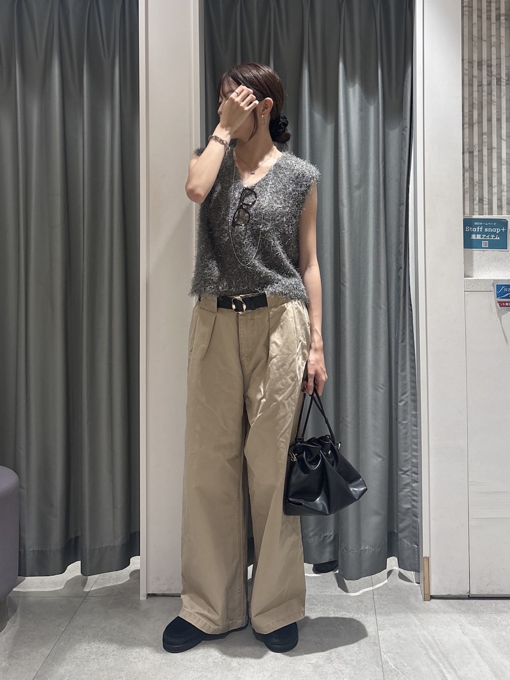 グレー系のニット/セーター、ベージュ系のチノパンツ、ブラック系のトートバッグを着用したレディースの秋コーディネートの2枚目の写真